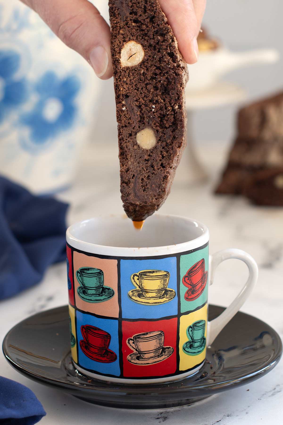 a biscotti dunking into a cup of coffee. 