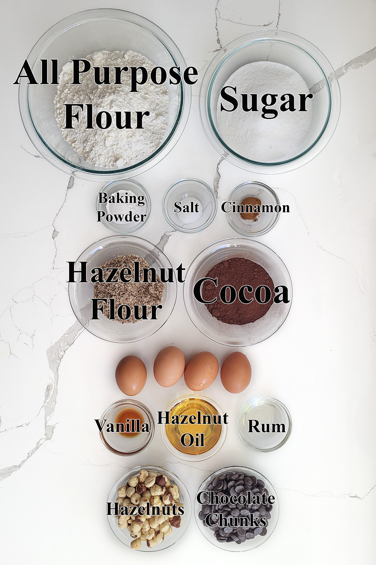 ingredients for hazelnut chocolate biscotti in glass bowls.