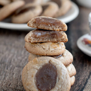 a stack of chestnut cookies on a wooden surface.