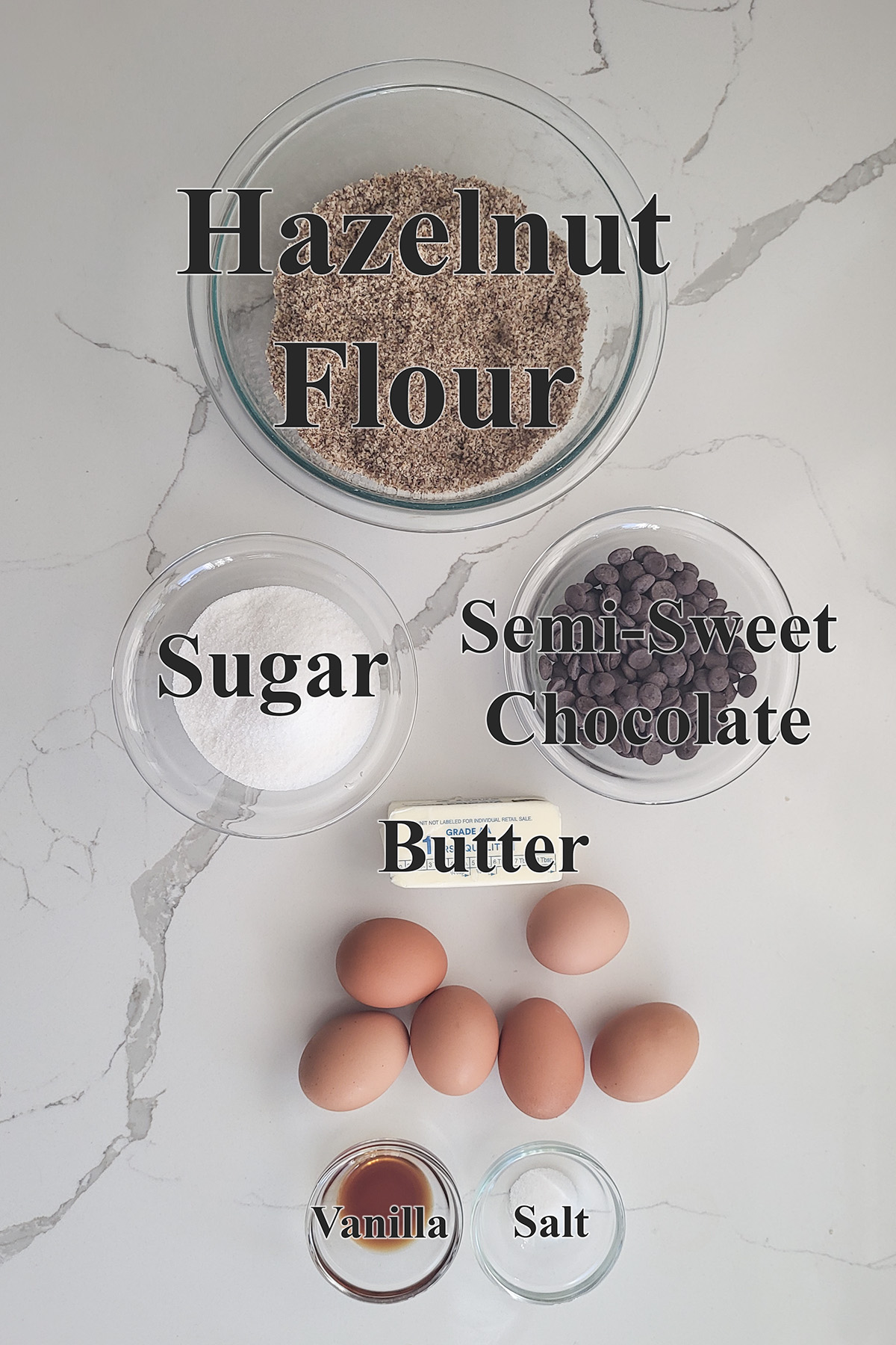 ingredients for chocolate hazelnut cake in glass bowls.