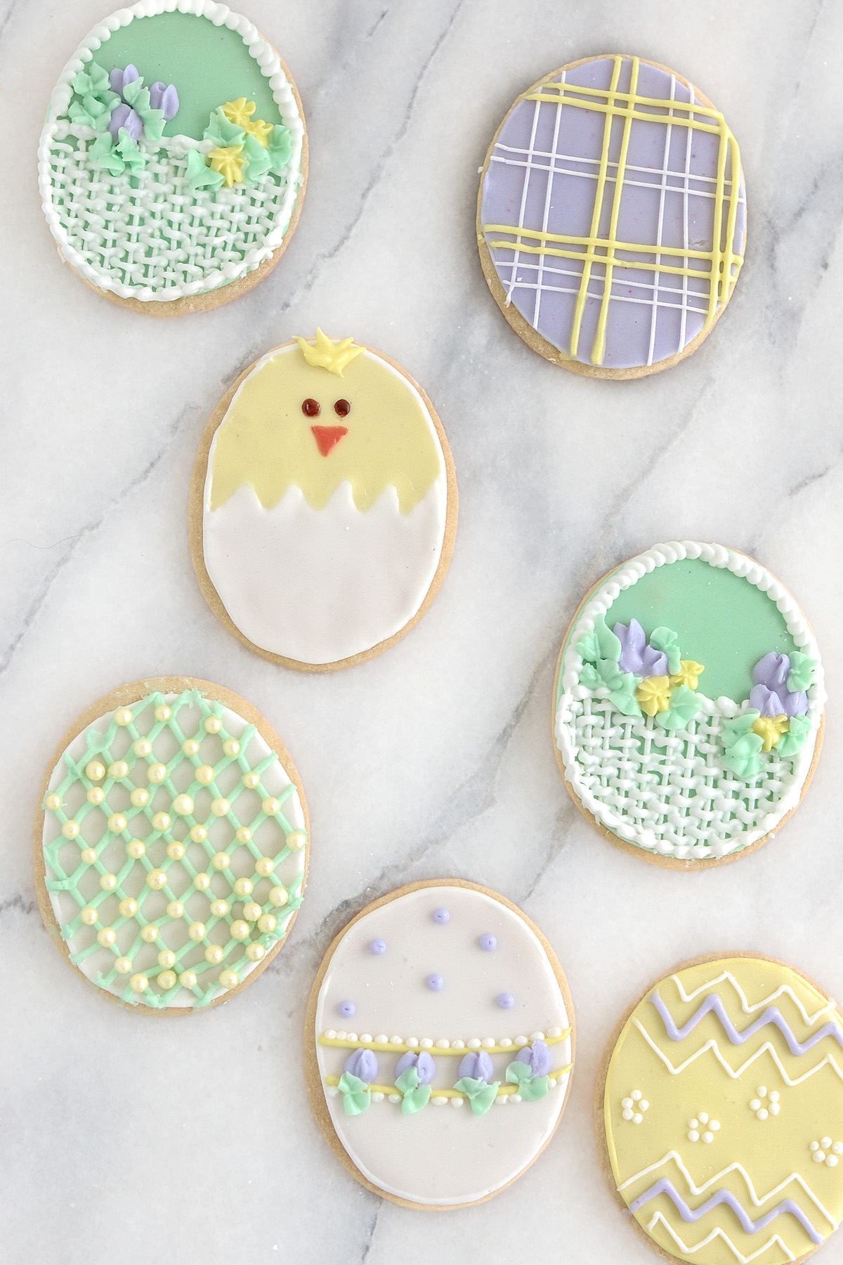 decorated sugar cookies on a marble surface.