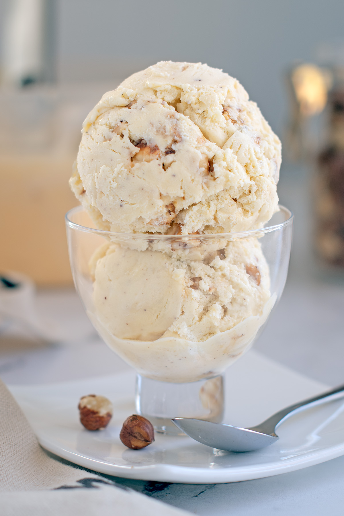 a glass dish filled with 2 scoops of hazelnut ice cream.