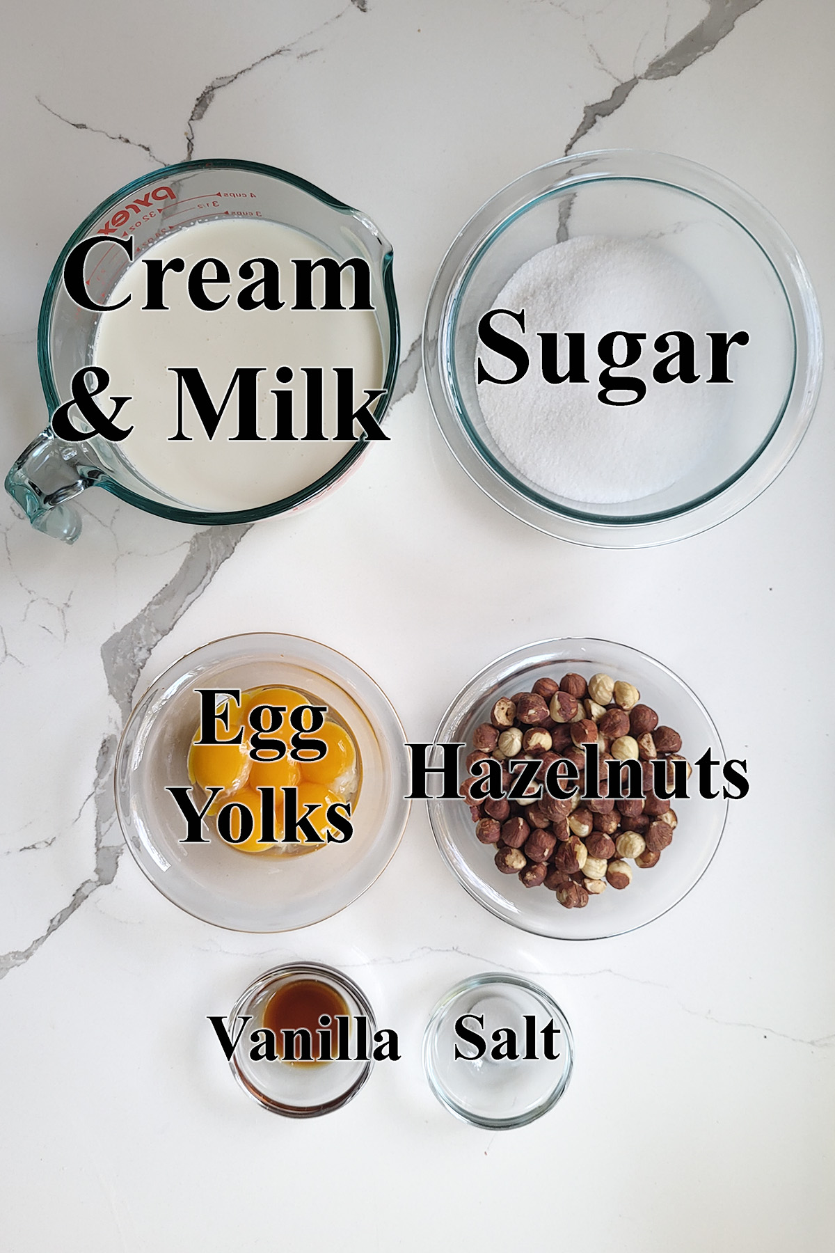 ingredients for homemade hazelnut ice cream in glass bowls.