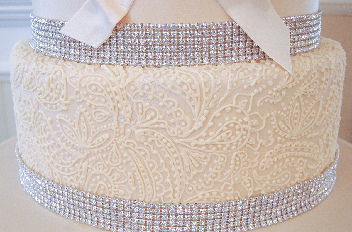 a closeup of a cake layer with intricate royal icing piping.