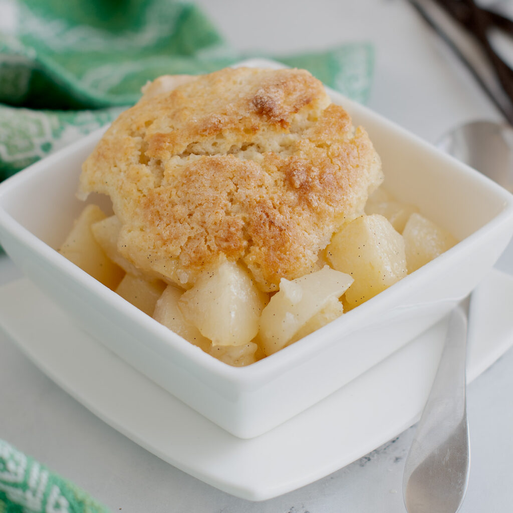 a white bowl filled with pear cobbler.