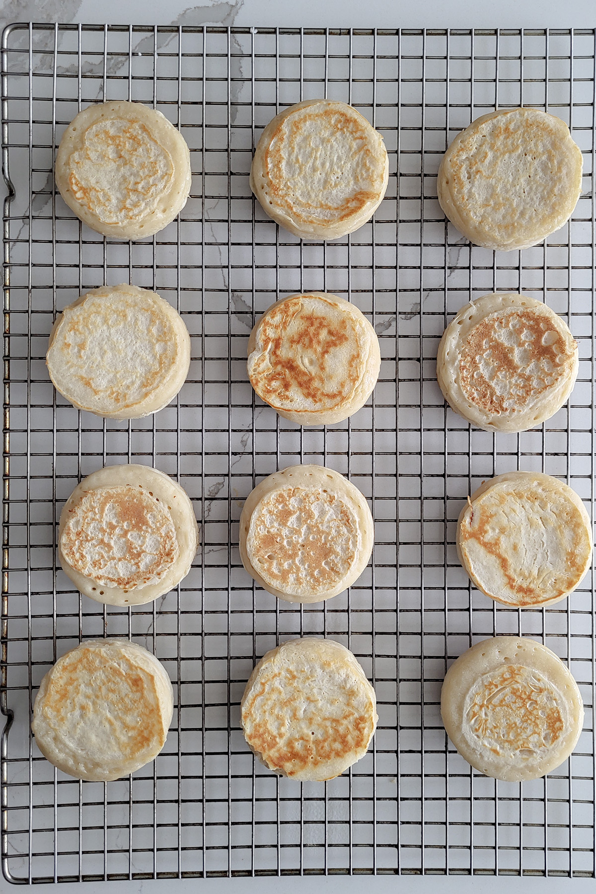 sourdough crumpets on a cooling rack.