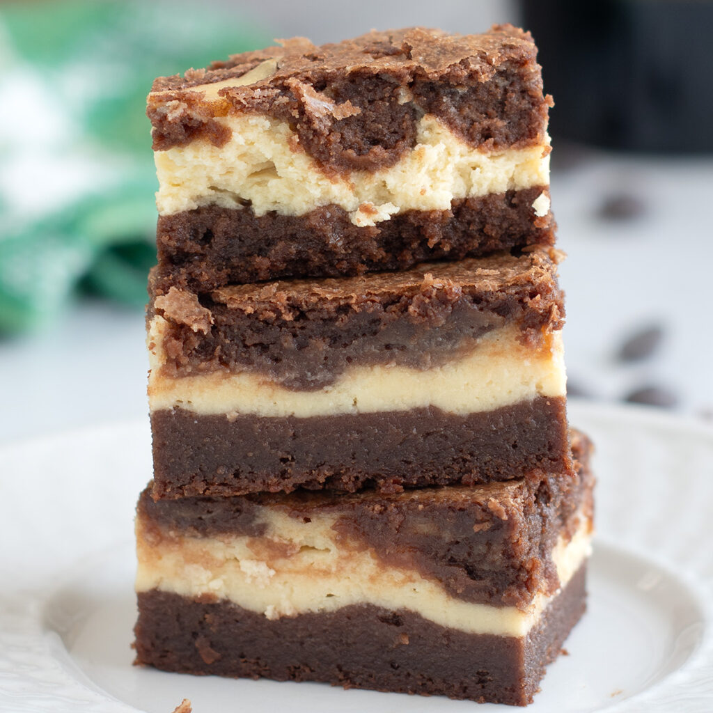 three baileys brownies stacked on a white plate.