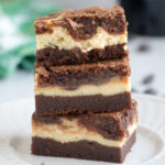 three baileys brownies stacked on a white plate.